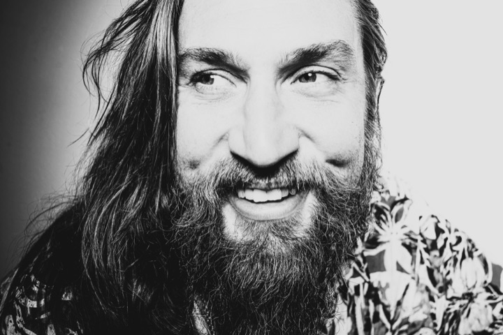 Black and white photograph of a bearded man laughing