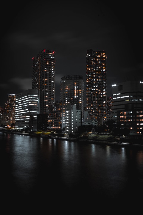 Skyscrapers lit at night beside the water