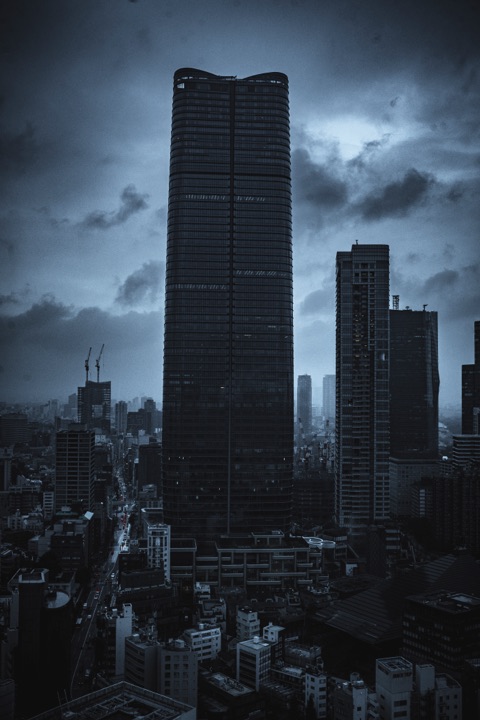 Dark skyscraper under heavy storm clouds