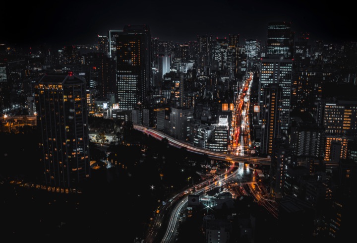 Night city seen from above with light trails on the roads