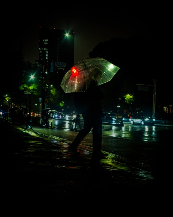 Person with a clear umbrella on a rainy night street