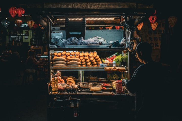 Street-food stall at night with a vendor and glowing lanterns