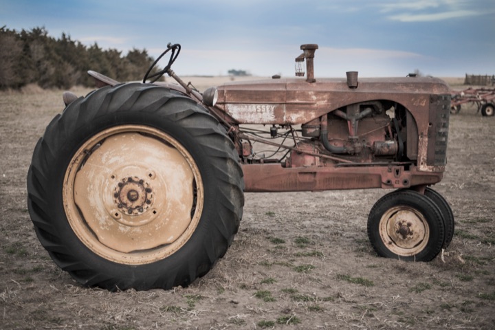 Rusty vintage tractor in a dry field